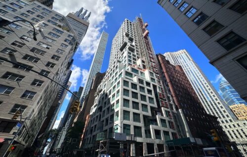 The Malabar Residences at 126 East 57th Street under construction in Midtown East, Manhattan, showing the tower’s concrete façade and glass railings nearing completion.
